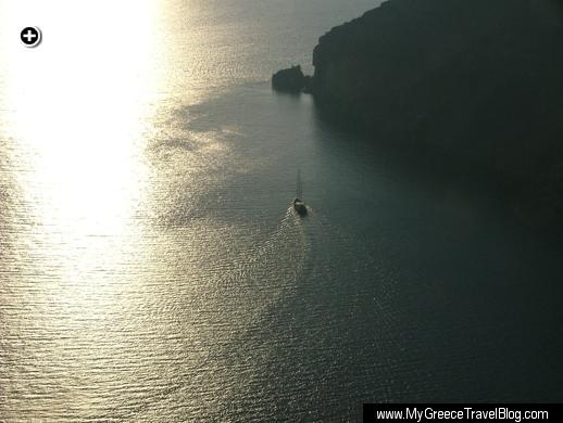 A sailboat passes close to Skaros Rock during a sunset cruise at Santorini