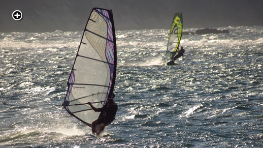 Windsurfers catch some waves and late afternoon sun on St George's Bay near Naxos Town 