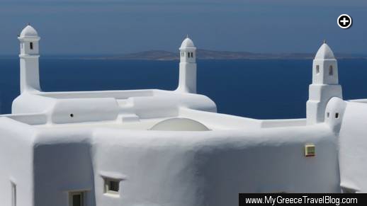 Traditionally designed chimneys rise from the roof of a private villa on Mykonos