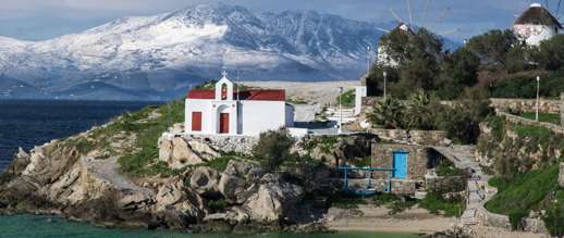 Achim Eckhardt photo of Tinos in the background behind Agios Charalampos church in Mykonos Town