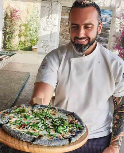 Executive chef Nikos Sotiropoulos with displays his Black Pizza creation at I Frati restaurant Mykonos