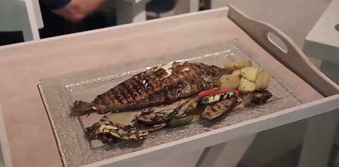Video screen capture of a fish dinner being served at Sealicious by Kounelas restaurant on Mykonos