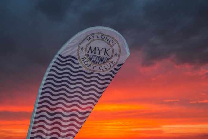 Mykonos Boat Club banner photographed at sunset